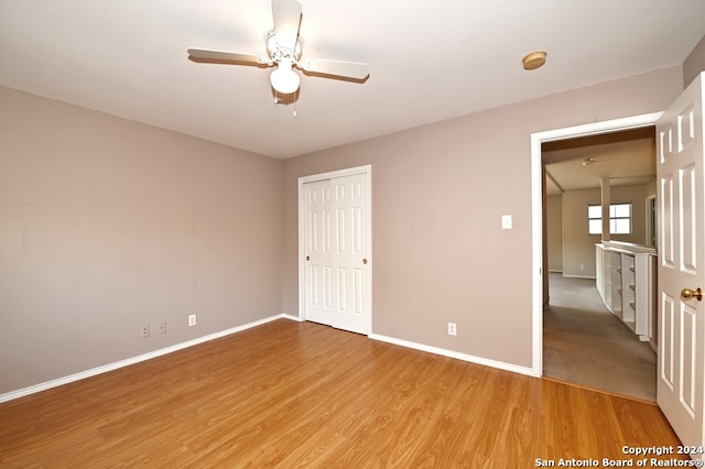 unfurnished bedroom with hardwood / wood-style flooring, a closet, and ceiling fan