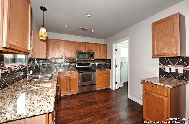 kitchen featuring dark hardwood / wood-style floors, stainless steel appliances, sink, pendant lighting, and tasteful backsplash