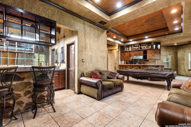 living room with a tray ceiling, a healthy amount of sunlight, crown molding, billiards, and light tile patterned floors