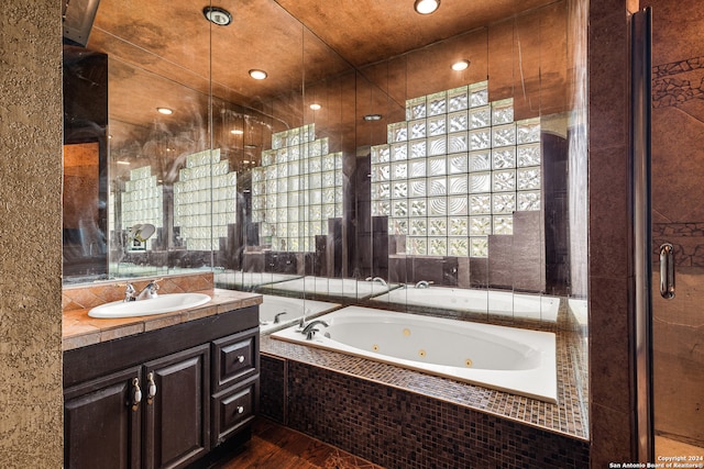 bathroom featuring vanity, hardwood / wood-style flooring, and separate shower and tub