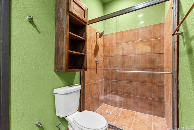 bathroom featuring toilet and a shower with door