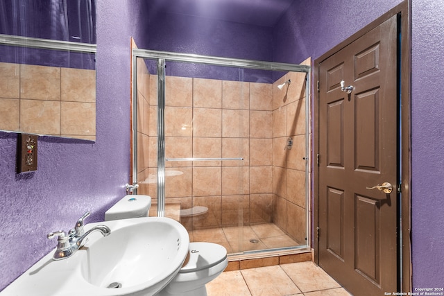 bathroom featuring tile patterned floors, sink, toilet, and an enclosed shower