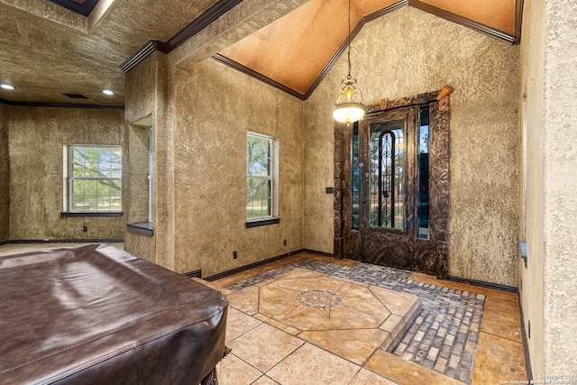 tiled foyer featuring crown molding and vaulted ceiling