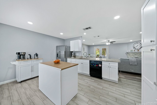 kitchen with dishwasher, kitchen peninsula, sink, stainless steel fridge with ice dispenser, and white cabinetry