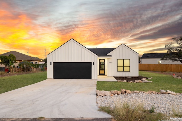 modern inspired farmhouse featuring a lawn and a garage