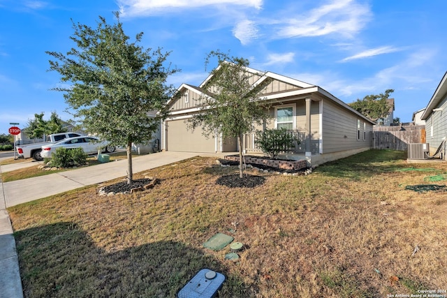 view of front of property featuring a garage, a front lawn, and central air condition unit