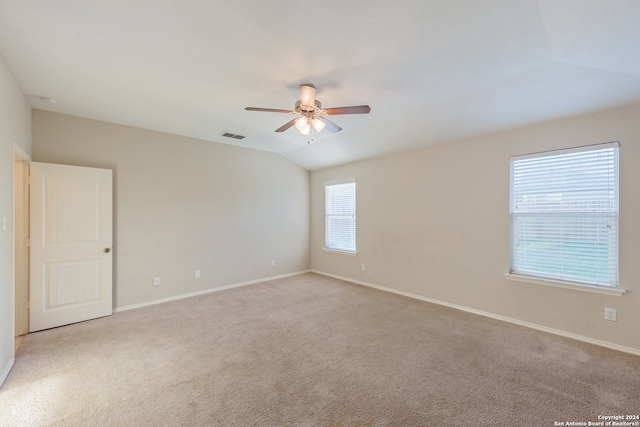 spare room with lofted ceiling, light colored carpet, and ceiling fan