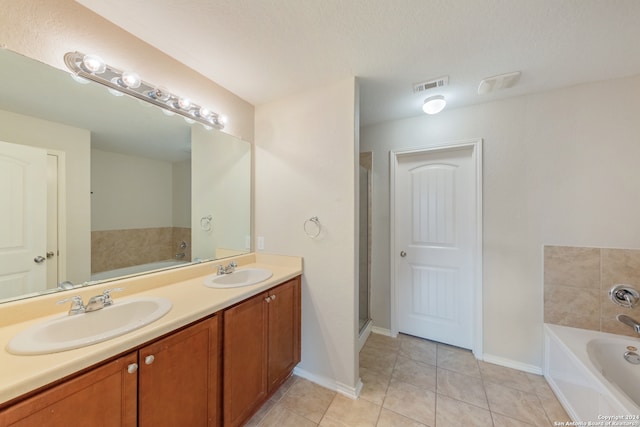 bathroom with vanity, separate shower and tub, a textured ceiling, and tile patterned flooring