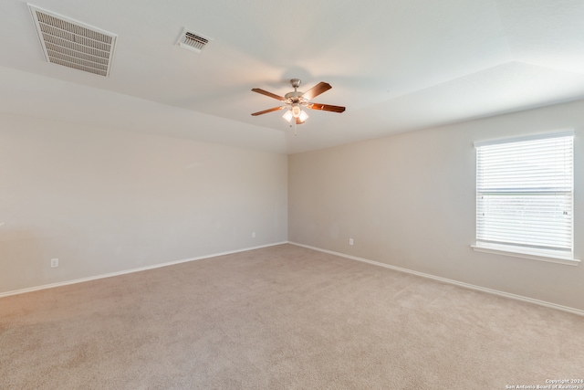 carpeted spare room with ceiling fan and vaulted ceiling