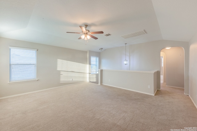 carpeted spare room featuring vaulted ceiling and ceiling fan