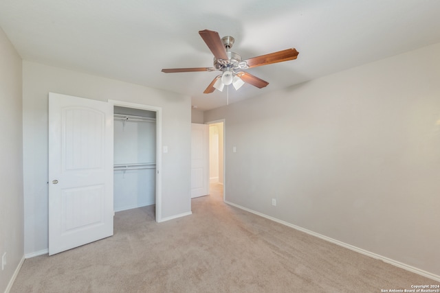 unfurnished bedroom with light carpet, a closet, and ceiling fan