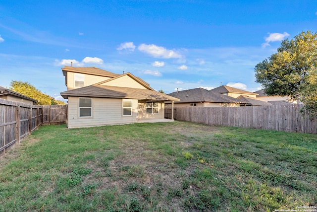 rear view of house featuring a yard