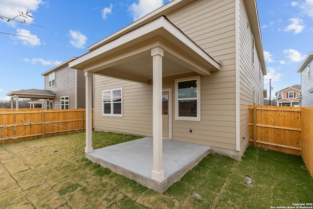 back of property featuring a lawn and a patio