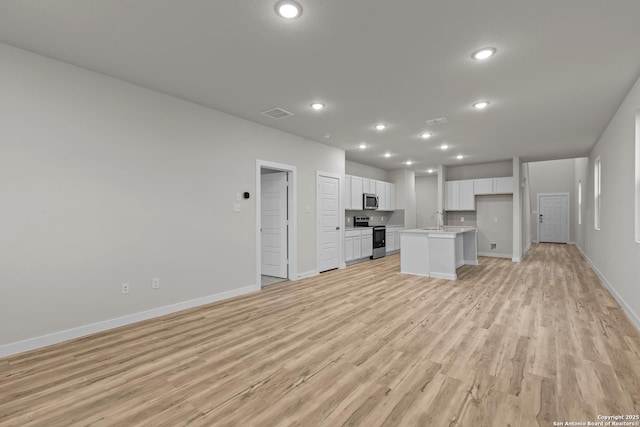 unfurnished living room with light wood-type flooring and sink