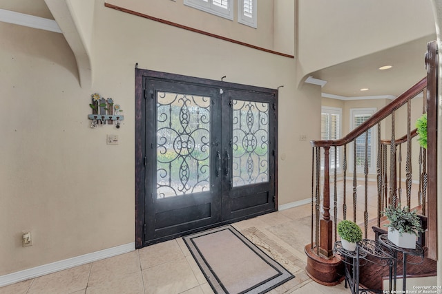 entryway featuring french doors, ornamental molding, and light tile patterned floors