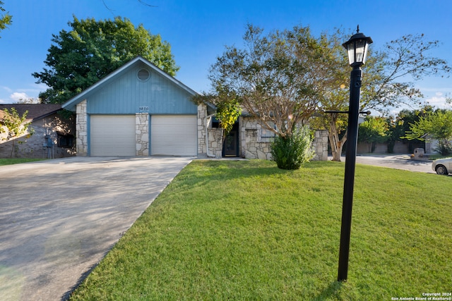 ranch-style house featuring a front yard and a garage