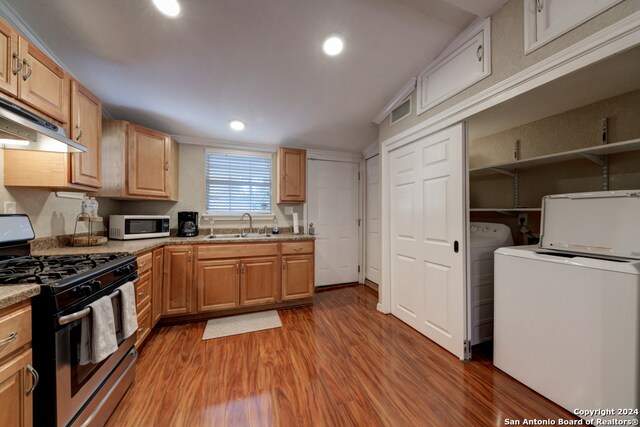 kitchen featuring light brown cabinetry, sink, stainless steel gas stove, light stone counters, and light hardwood / wood-style floors