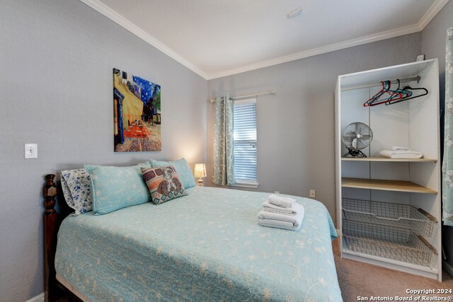 carpeted bedroom with ornamental molding