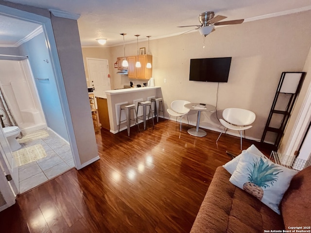 living room featuring crown molding, ceiling fan, and dark wood-type flooring