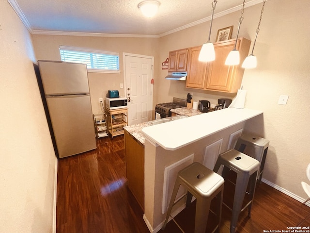 kitchen with white appliances, a breakfast bar area, dark wood-type flooring, hanging light fixtures, and kitchen peninsula