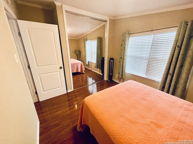 bedroom with a closet, ornamental molding, and dark hardwood / wood-style floors