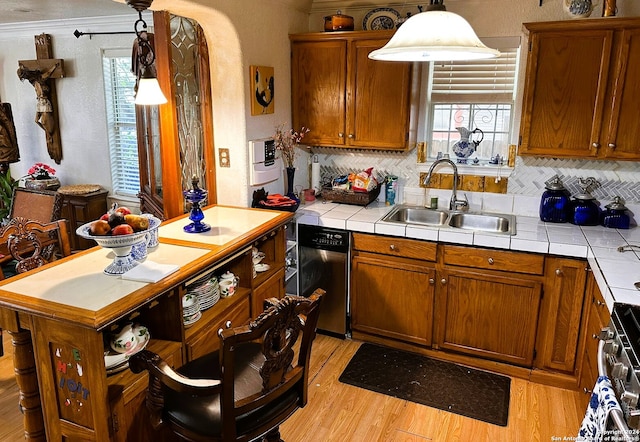 kitchen featuring tile countertops, sink, crown molding, and decorative light fixtures