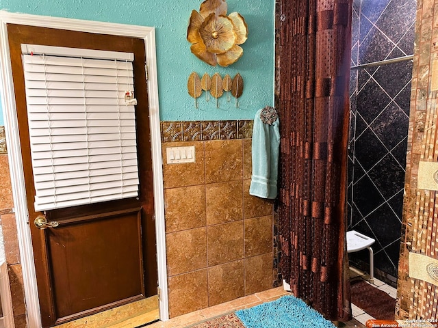 bathroom with tile walls and tile patterned flooring