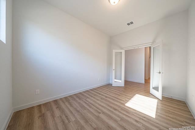 unfurnished bedroom featuring baseboards, visible vents, and light wood-style flooring