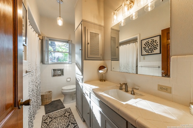 bathroom featuring toilet, vanity, tile patterned floors, and tile walls