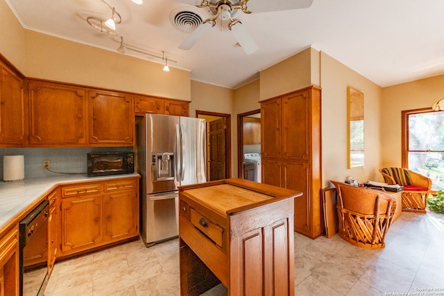 kitchen featuring dishwasher, track lighting, a kitchen island, washer / dryer, and stainless steel refrigerator with ice dispenser