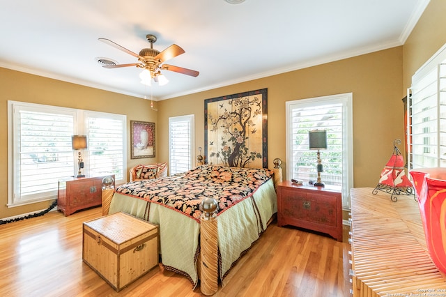 bedroom with ceiling fan, crown molding, and light wood-type flooring