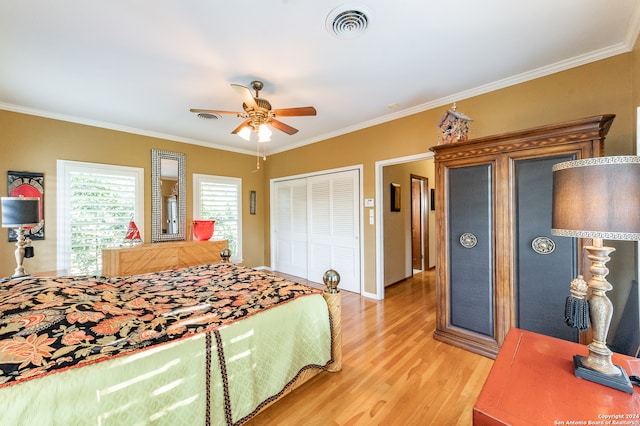 bedroom with a closet, ornamental molding, light wood-type flooring, and ceiling fan