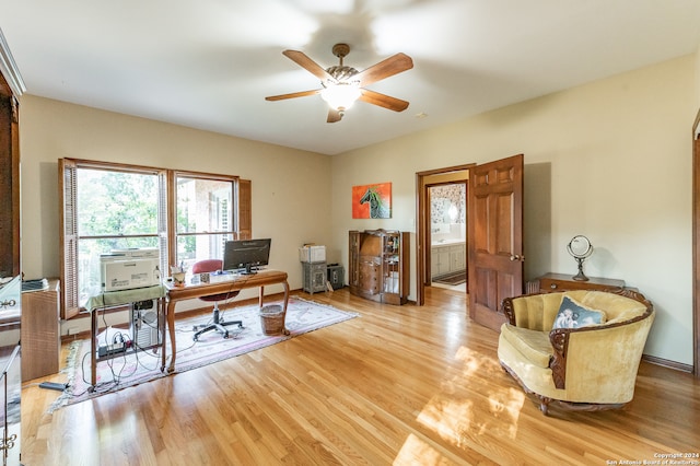 office with light hardwood / wood-style floors and ceiling fan