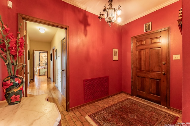 entryway featuring crown molding and a chandelier