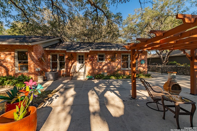 rear view of property with a pergola, a patio area, and central air condition unit