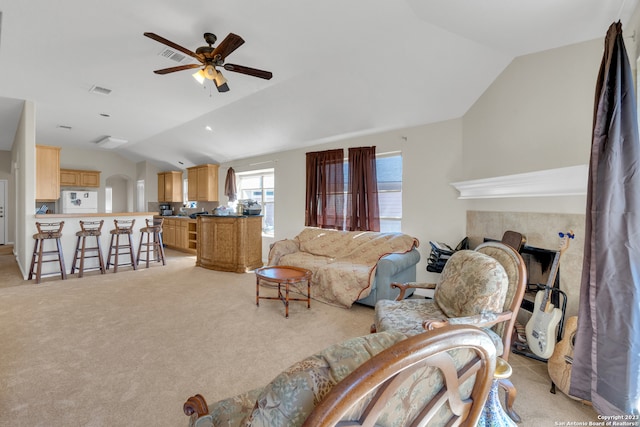 living room with ceiling fan, lofted ceiling, and light colored carpet