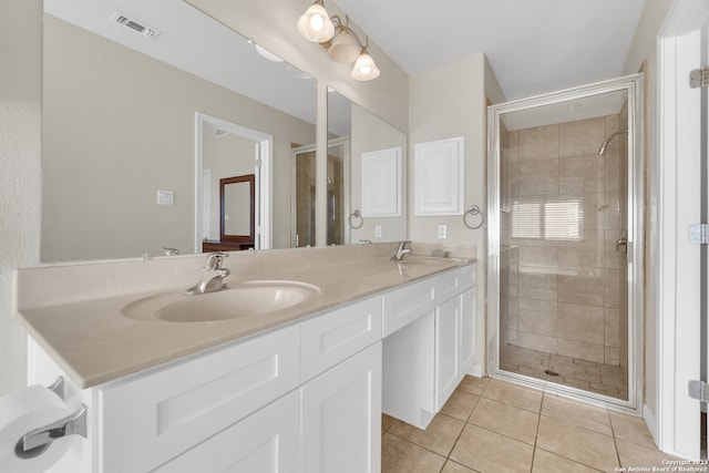 bathroom featuring a shower with door, vanity, and tile patterned flooring