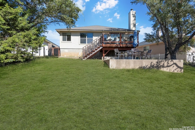 rear view of house featuring a deck and a yard