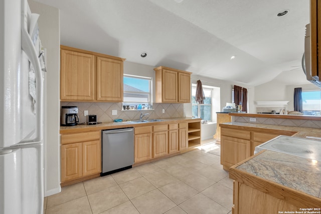 kitchen with dishwasher, white refrigerator, and light brown cabinets