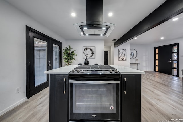 kitchen featuring french doors, island range hood, light wood-type flooring, a kitchen island, and black gas range