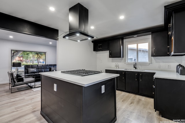 kitchen featuring sink, a center island, island range hood, light hardwood / wood-style floors, and stainless steel gas stovetop