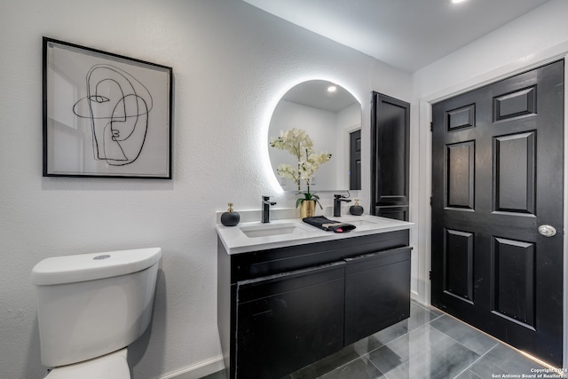 bathroom with tile patterned flooring, vanity, and toilet