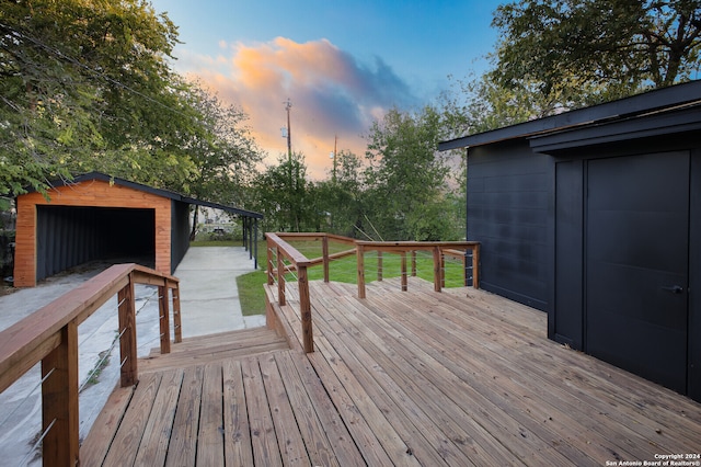 deck at dusk featuring an outbuilding