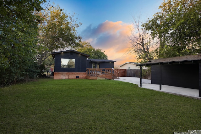 yard at dusk with a patio and a wooden deck