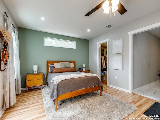 bedroom featuring a spacious closet, ceiling fan, a closet, and wood-type flooring