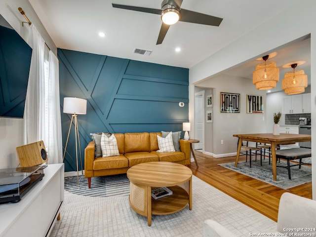 living room with light hardwood / wood-style floors and ceiling fan