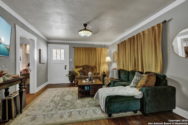 living room with a textured ceiling, ornamental molding, and wood-type flooring