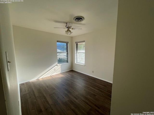 spare room with dark wood-type flooring and ceiling fan