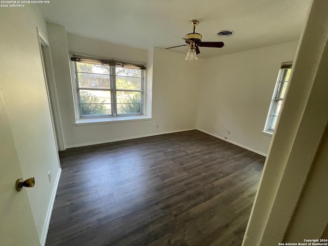 spare room with dark wood-type flooring and ceiling fan