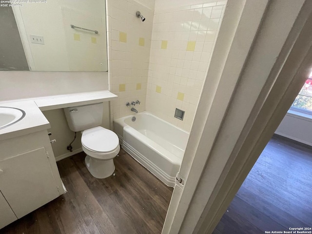 full bathroom with tiled shower / bath, vanity, hardwood / wood-style floors, and toilet